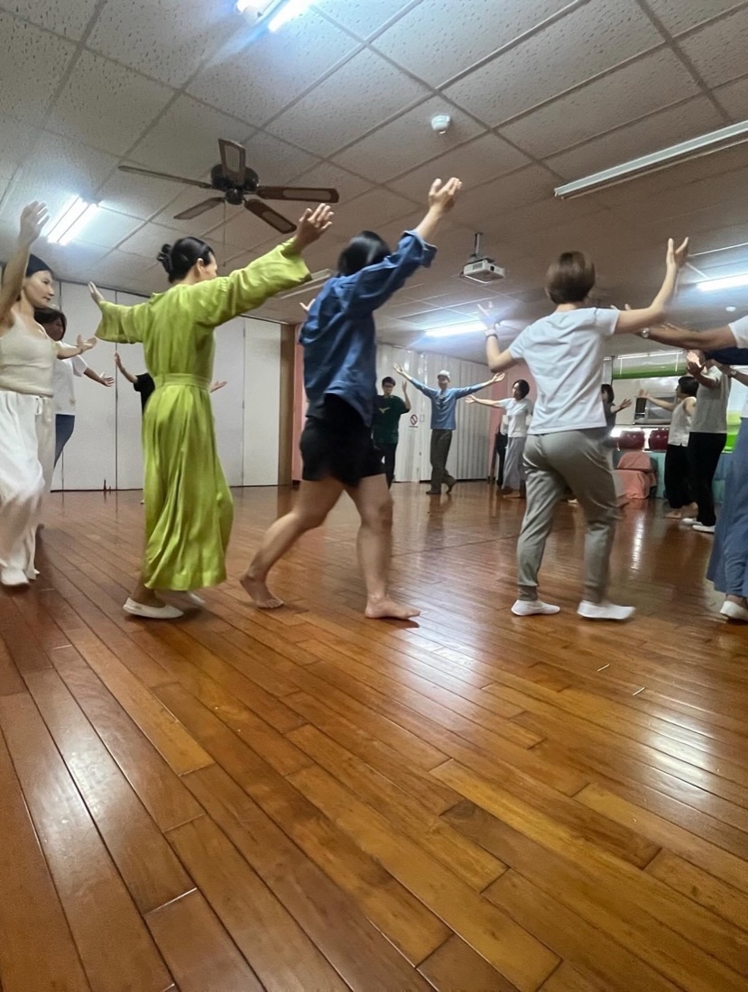 成人優律思美課堂，學員在木地板教室中伸展手臂做律動